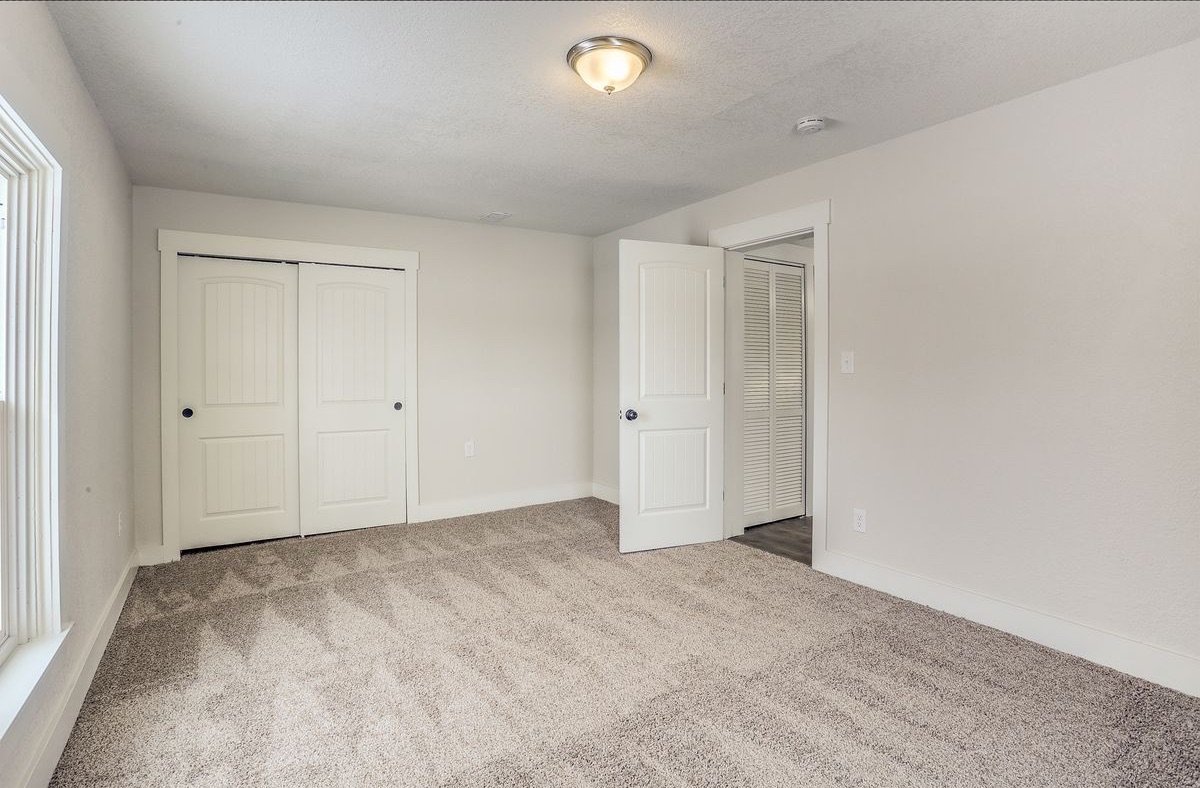 Bedroom after: new drywall, fresh white paint, trim and doors