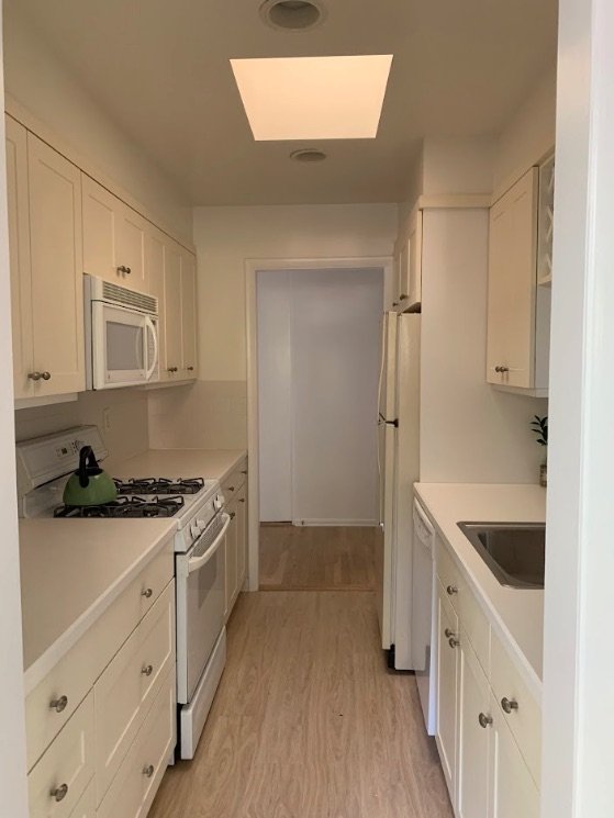 Galley kitchen with repainted cream cabinets