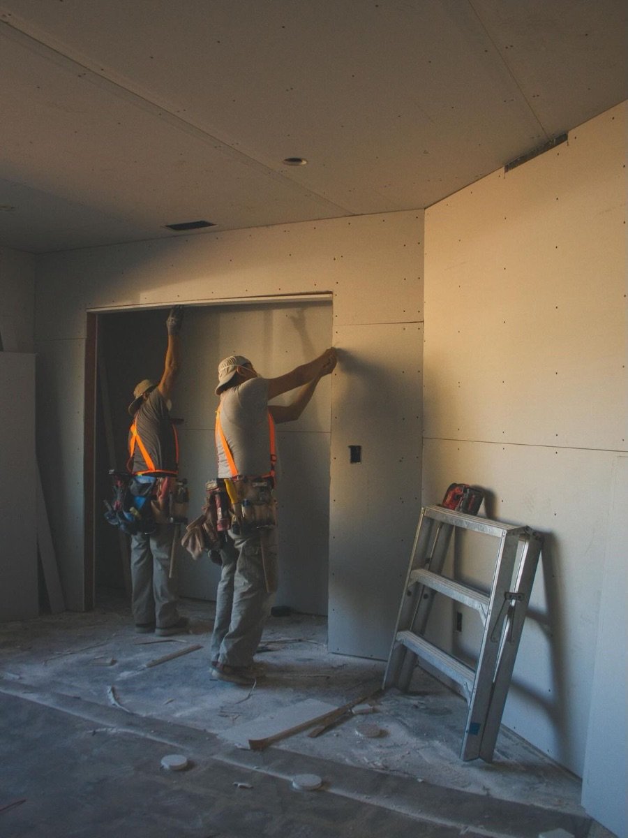 Two installers hanging drywall panels