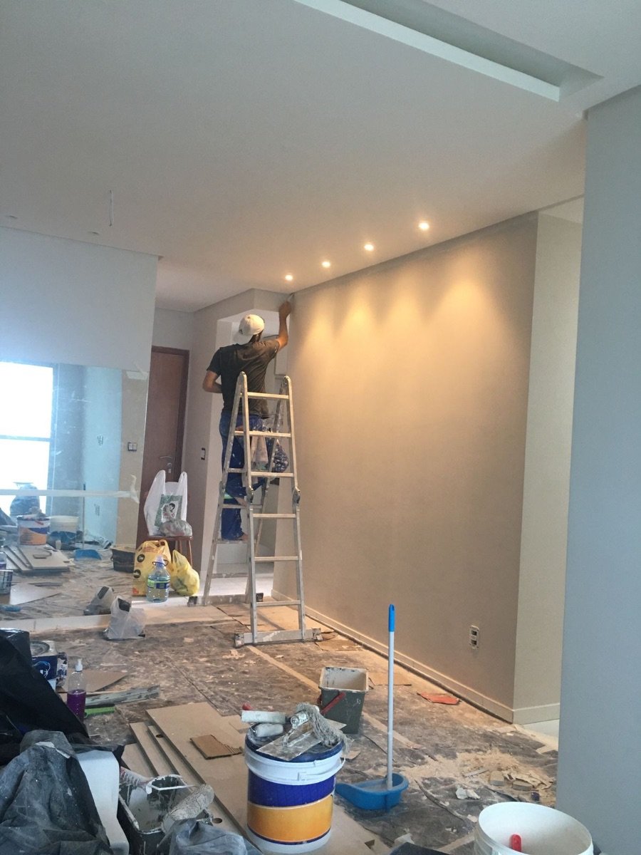 Painter on a ladder cutting in along the ceiling line