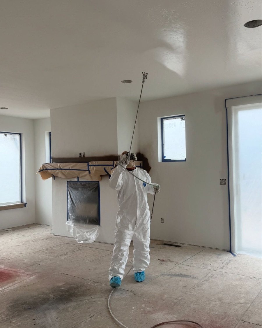 Painter in protective suit spraying a ceiling